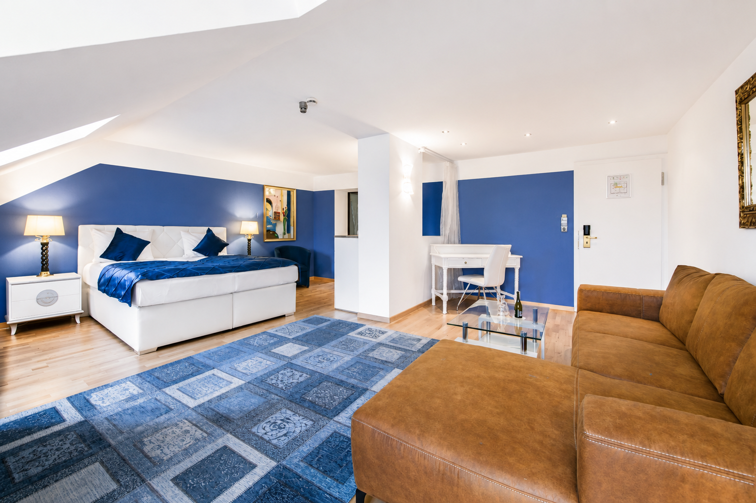 Helles Superior-Zimmer im Hotel Rivoli München mit blauen Akzenten und Lounge-Bereich